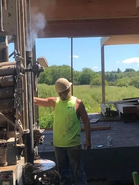 Herr Well Drilling operator working the rig controls while drilling a residential well near Oconomowoc, WI
