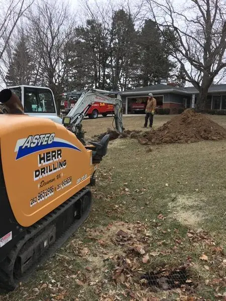 Herr Drilling equipment and crew running a new service line across a residential yard