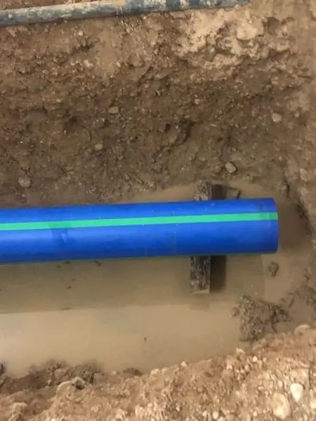 New blue water service line laid in an open trench during a well pump installation in New Berlin, WI
